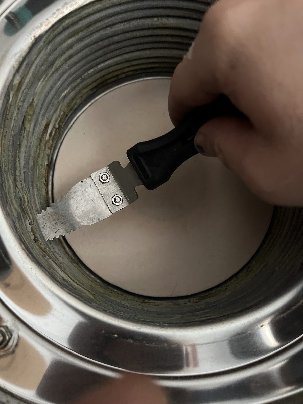 Cleaning inside a boiler combustion chamber with a scraper