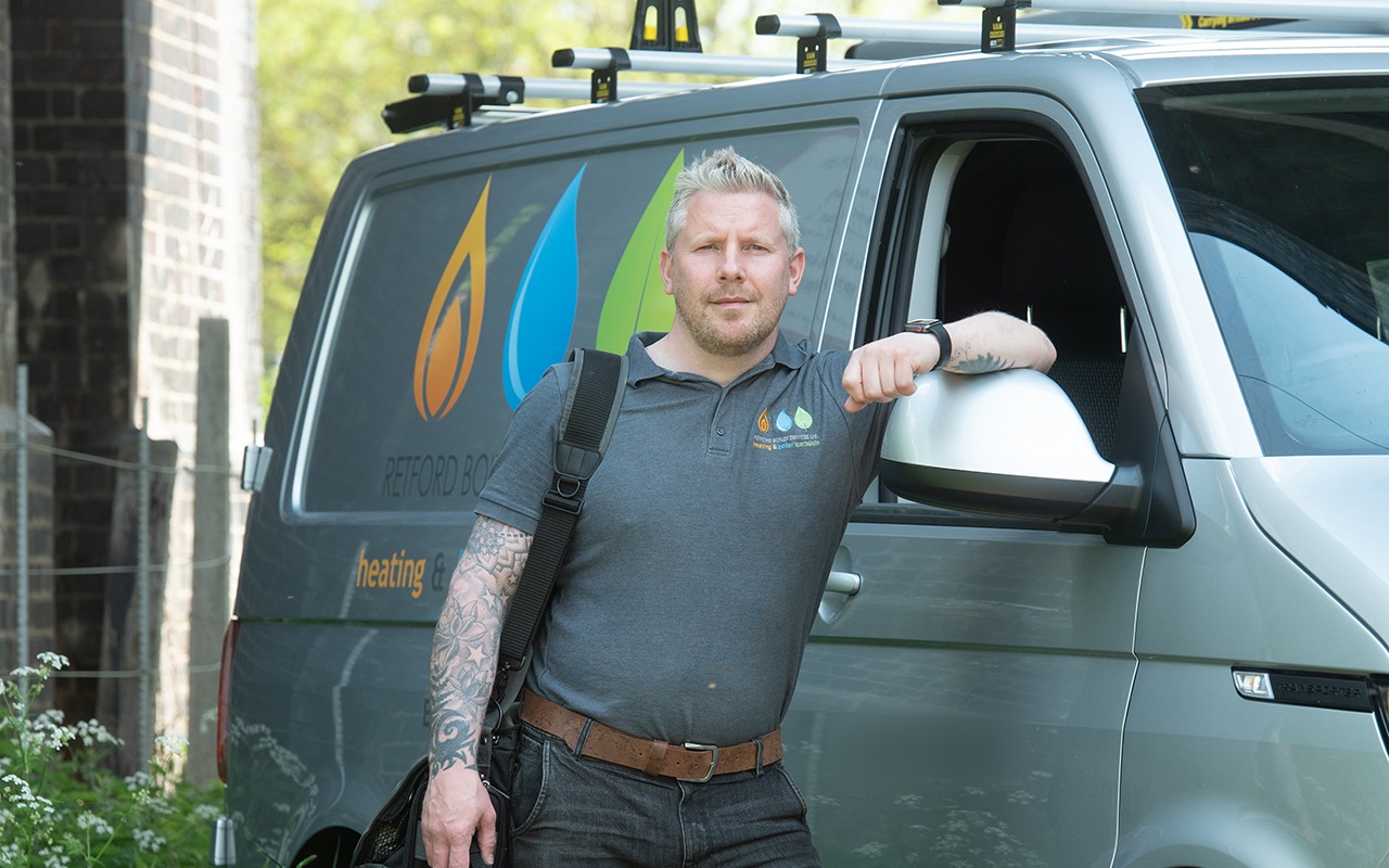 James Crabb leaning on his van with the flame, drop and leaf livery