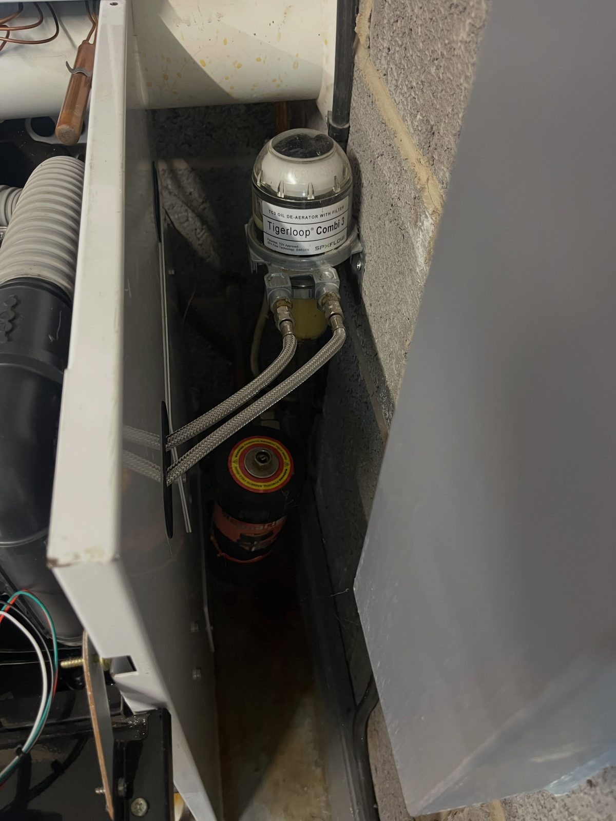 Inside the Navien boiler cabinet, the new filter and pipework